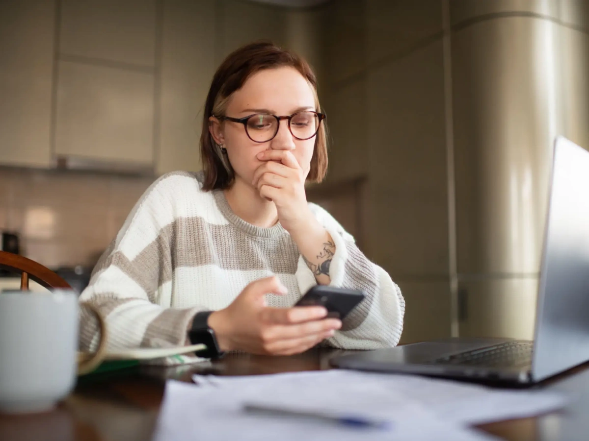 Thoughtful individual using mobile device indoors