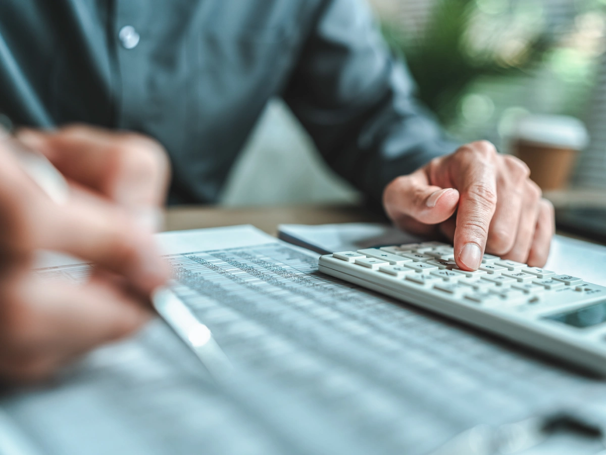 Close-up of hands with calculator and pen