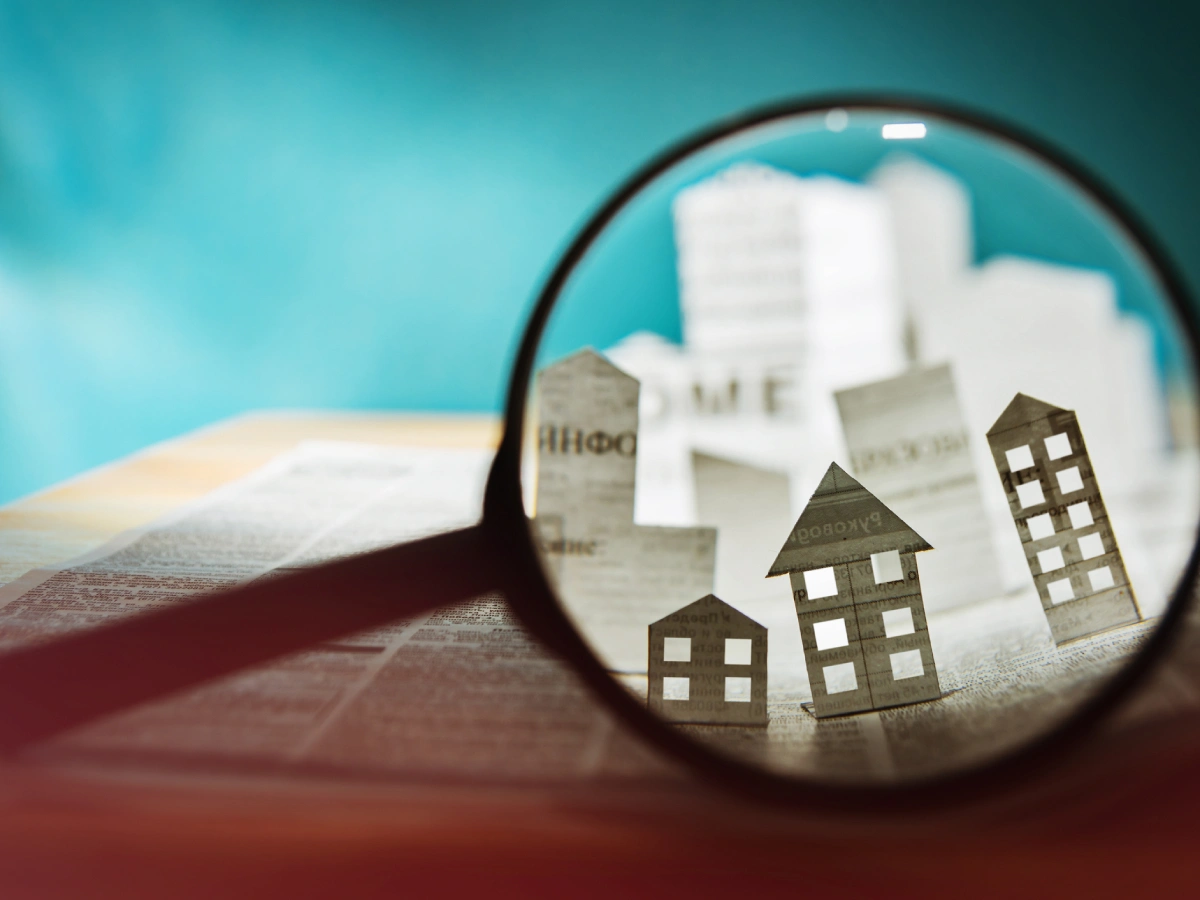 Newspaper with magnified paper houses