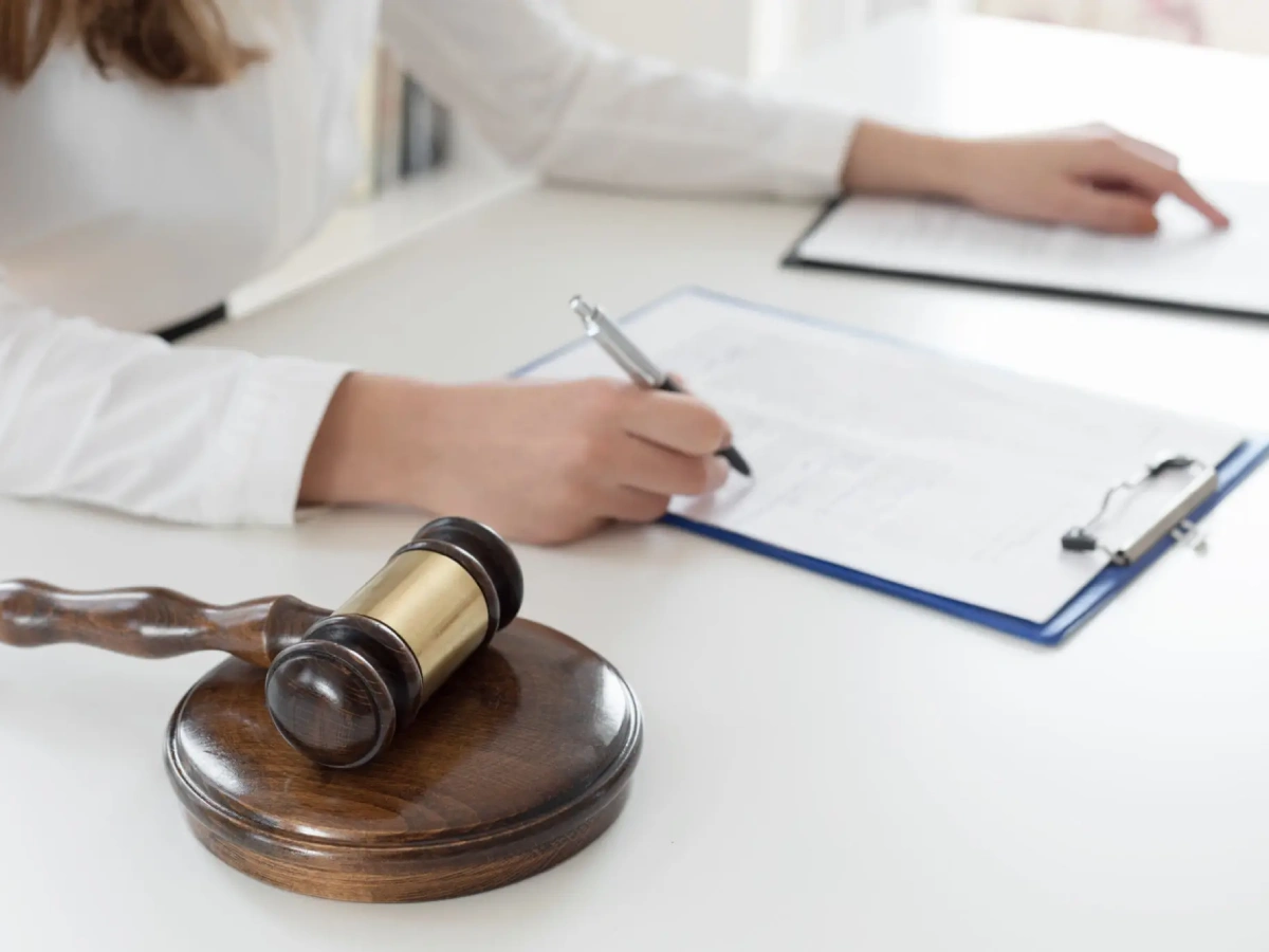 Lawyer writing with gavel nearby