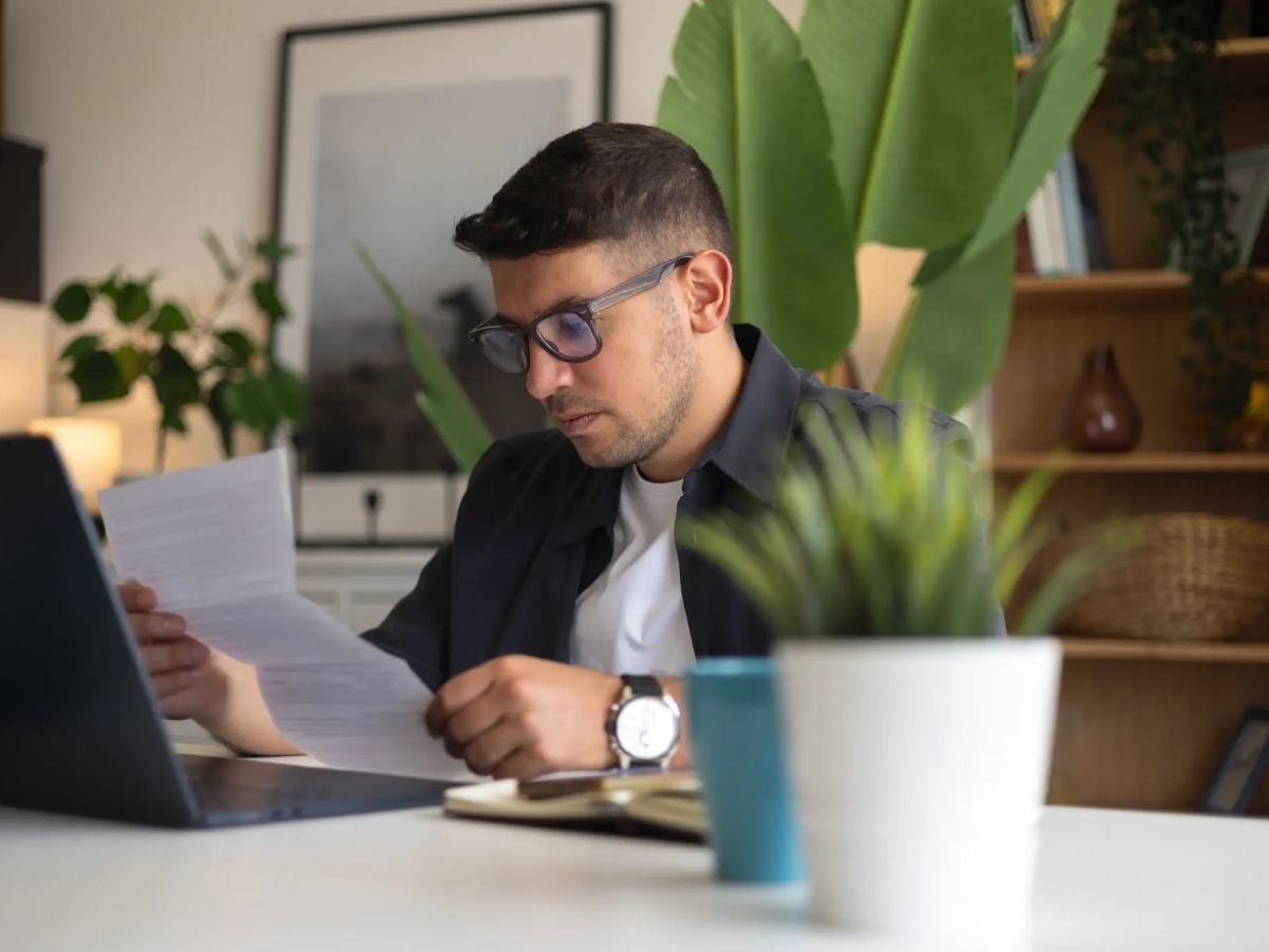 Person working with laptop and papers
